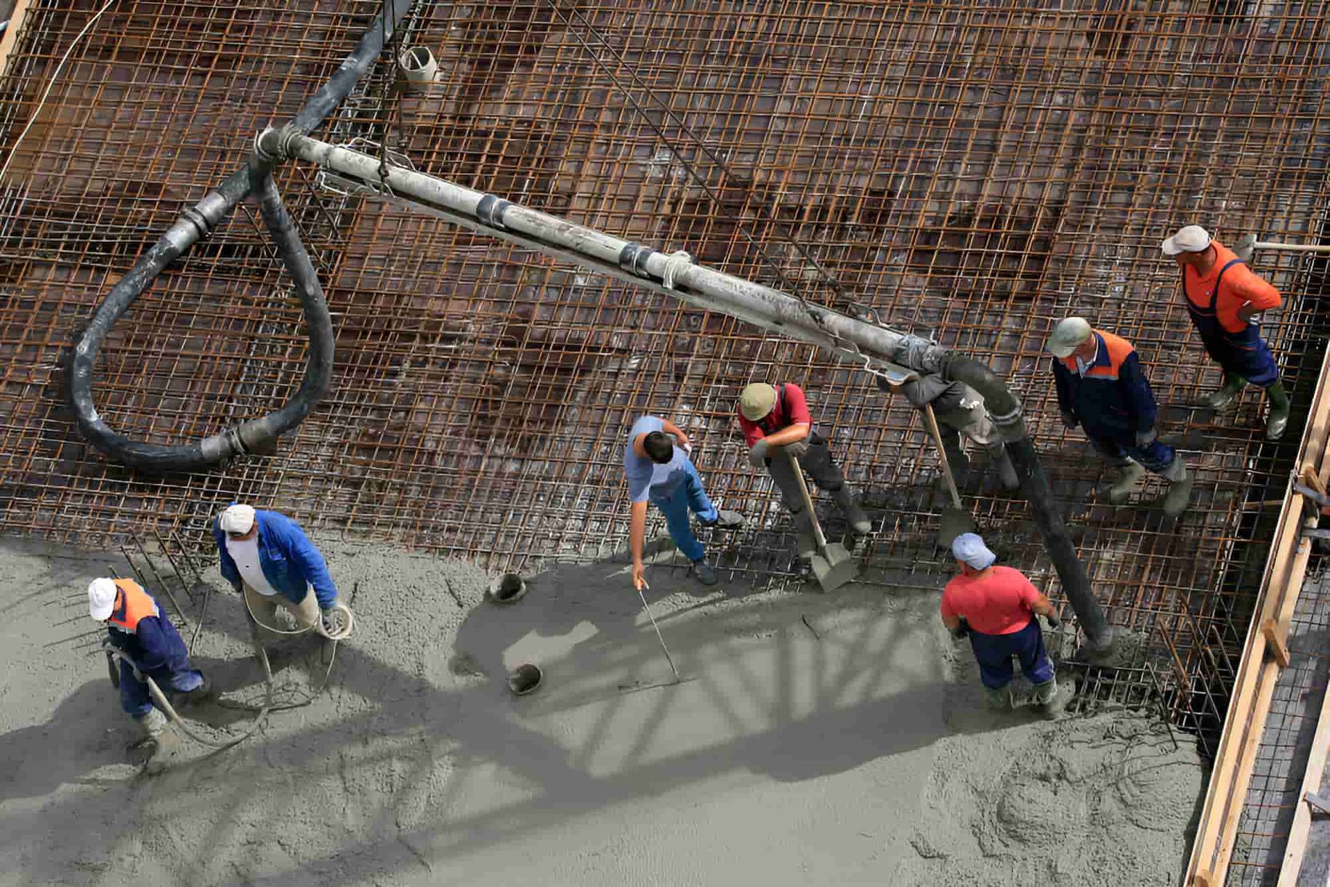 A Group Of Construction Workers Are Working On A Concrete Floor — JGA Concreting Pty Ltd In Berrimah, NT