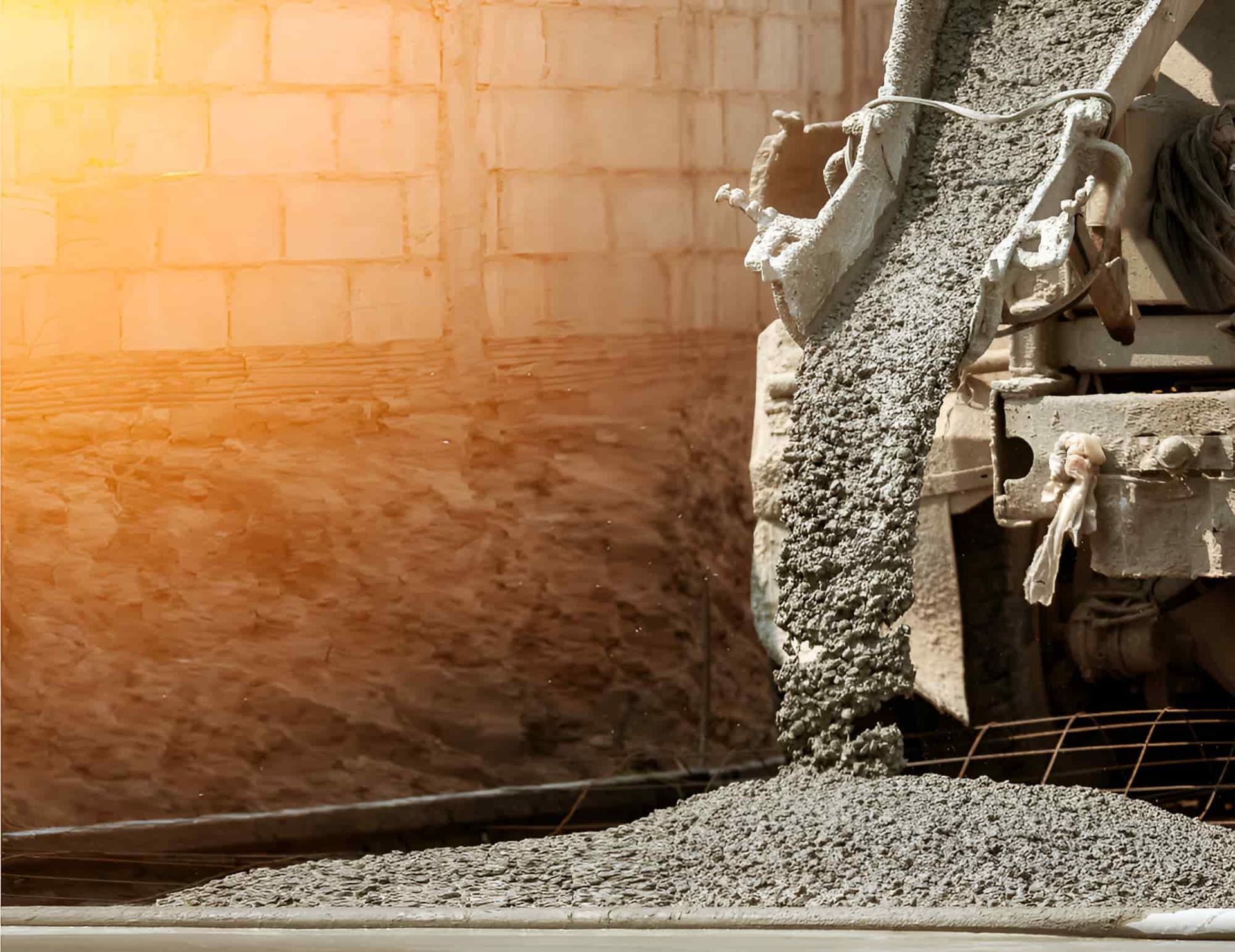 A Concrete Mixer Is Pouring Concrete Into A Bucket On A Construction Site — JGA Concreting Pty Ltd In Berrimah, NT