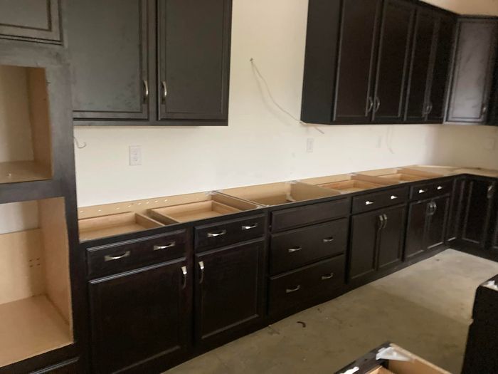 A kitchen with black cabinets and drawers is being remodeled