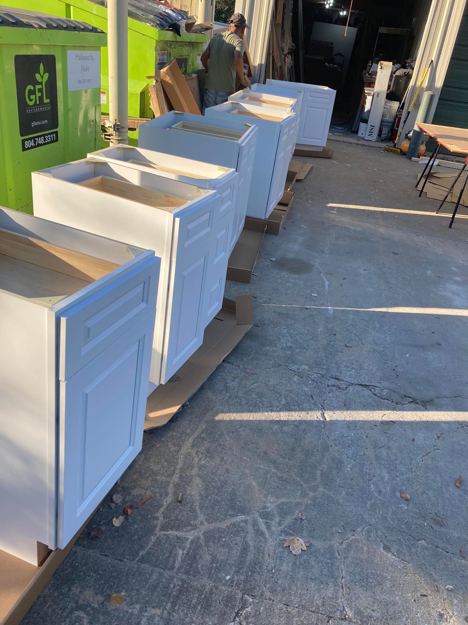 A row of white cabinets sitting on top of a concrete surface.