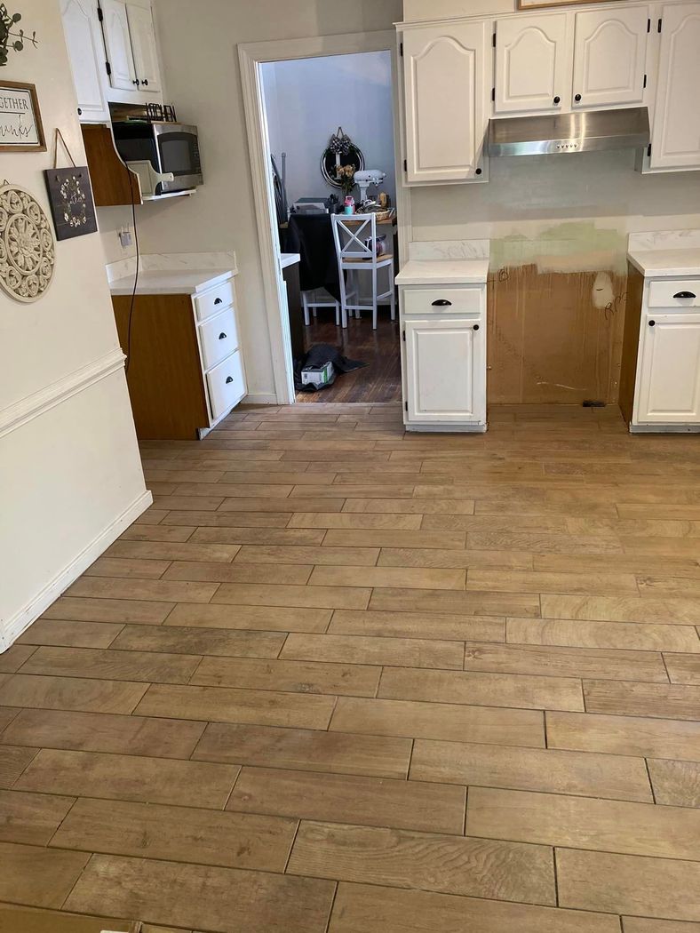 A kitchen with a wooden floor and white cabinets