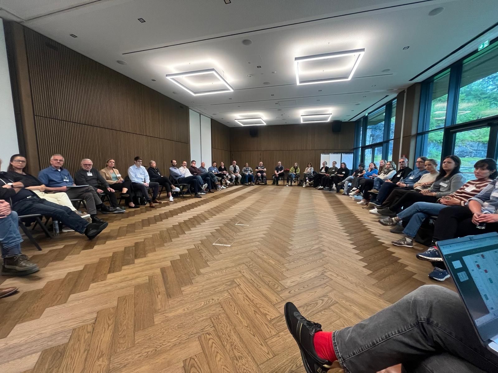Zahlreiche Teilnehmende aus unterschiedlichen sozialen Organisationen in einer großen Diskussionsrunde