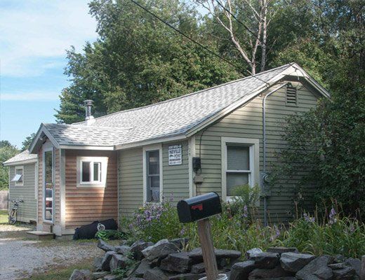 A small house with a mailbox in front of it