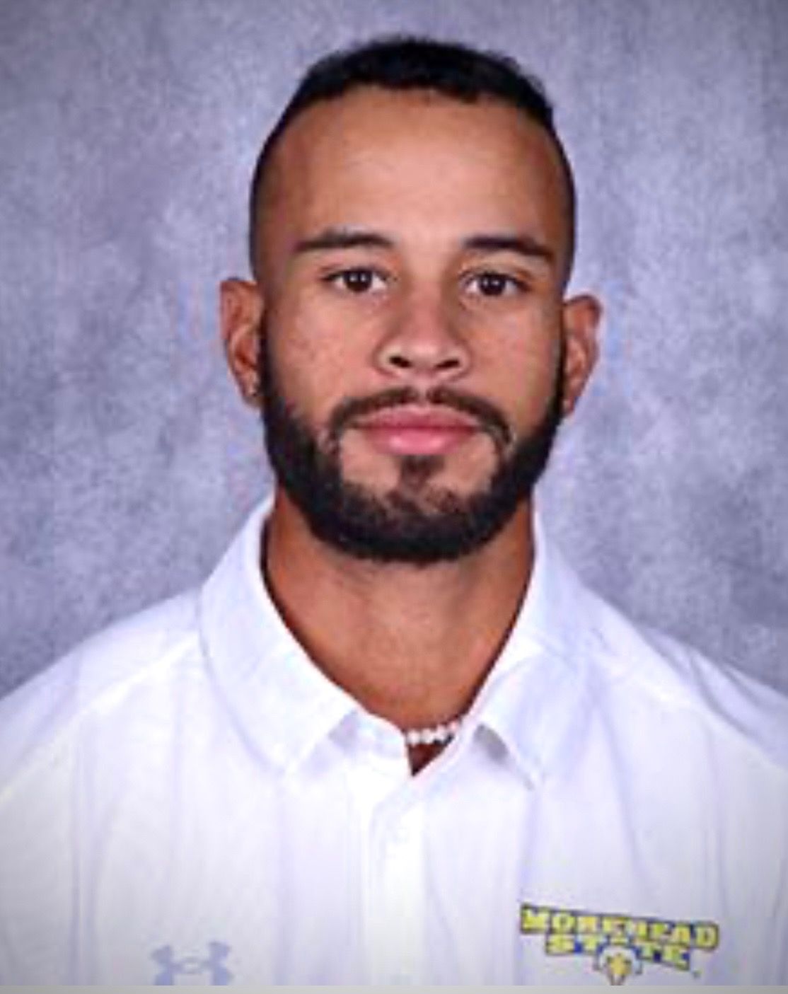 A man with a beard is wearing a white shirt