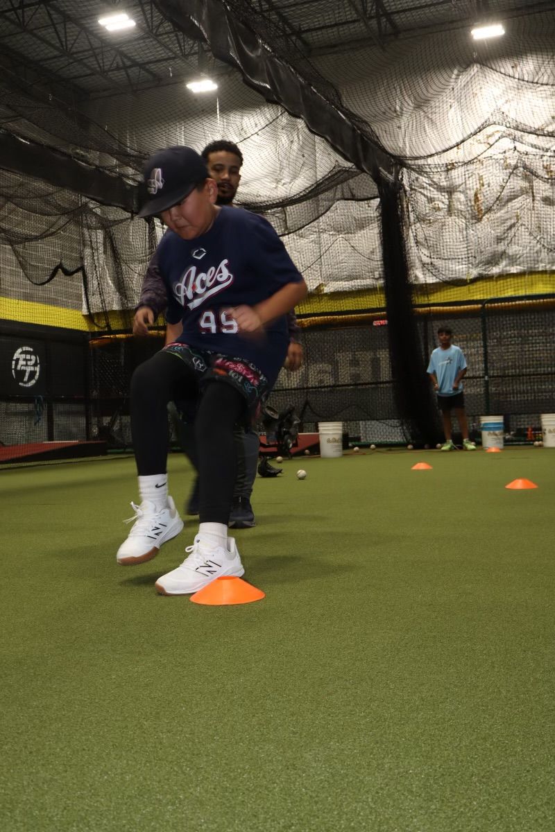 A group of baseball players are sitting in a dugout and smiling.