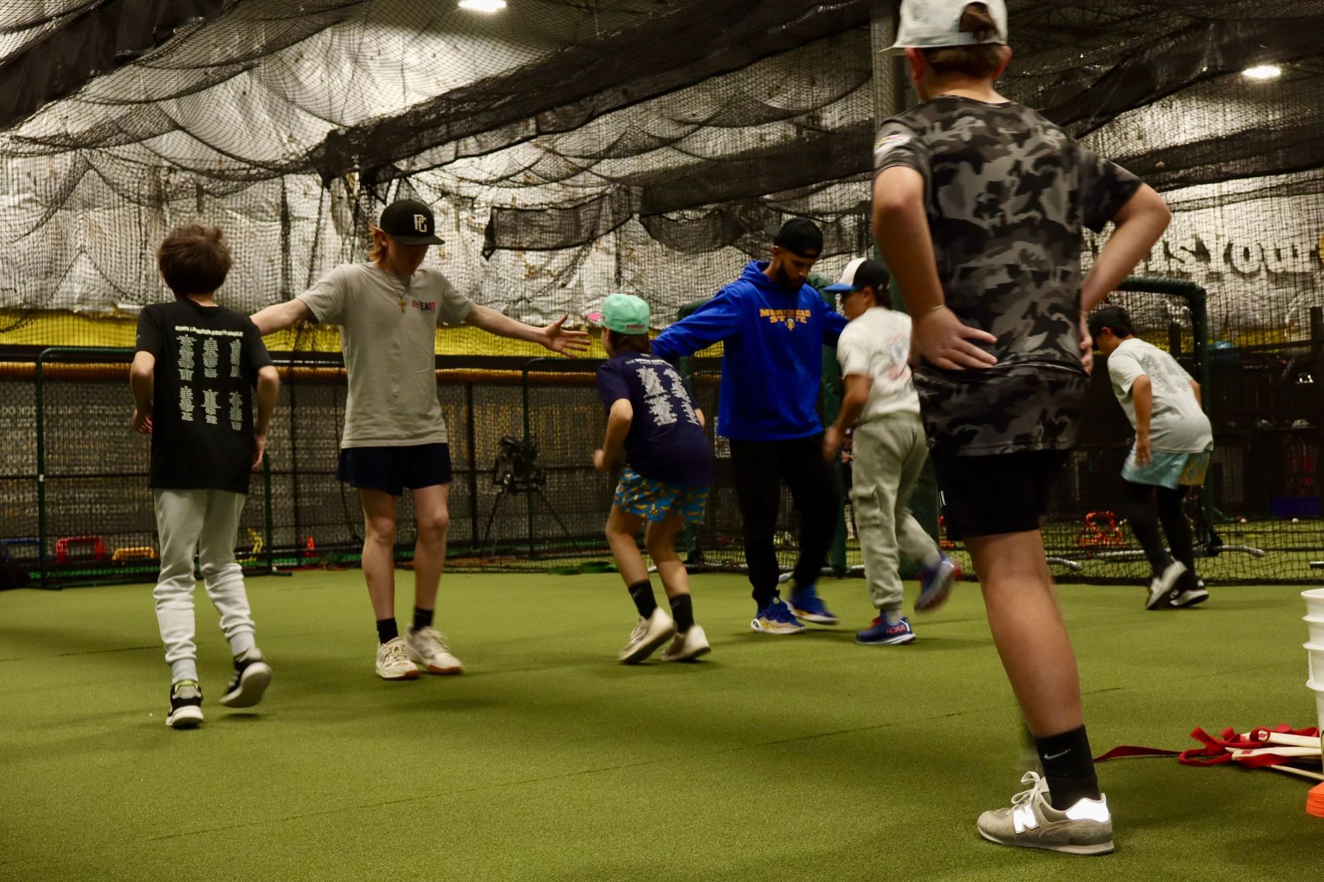 A man is standing next to a young boy on a baseball field.