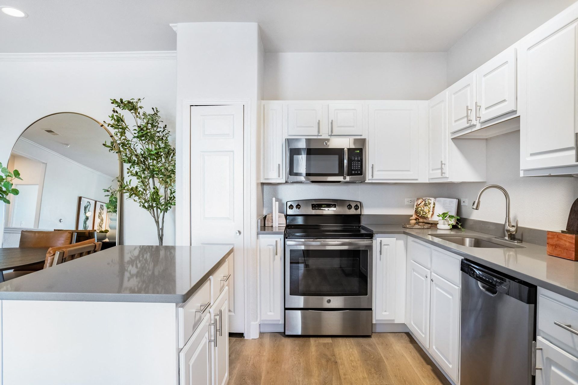 A modern kitchen with a stainless steel oven and white cabinets at The Viridian in Greenwood Village, CO.