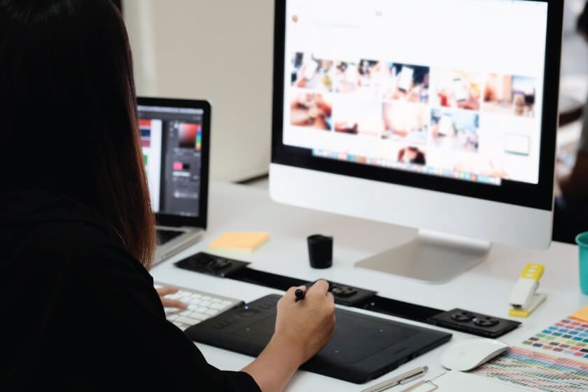 A woman is sitting at a desk with a computer