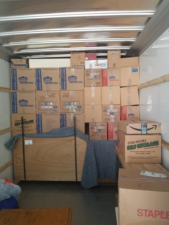 The inside of a moving truck filled with boxes and staples