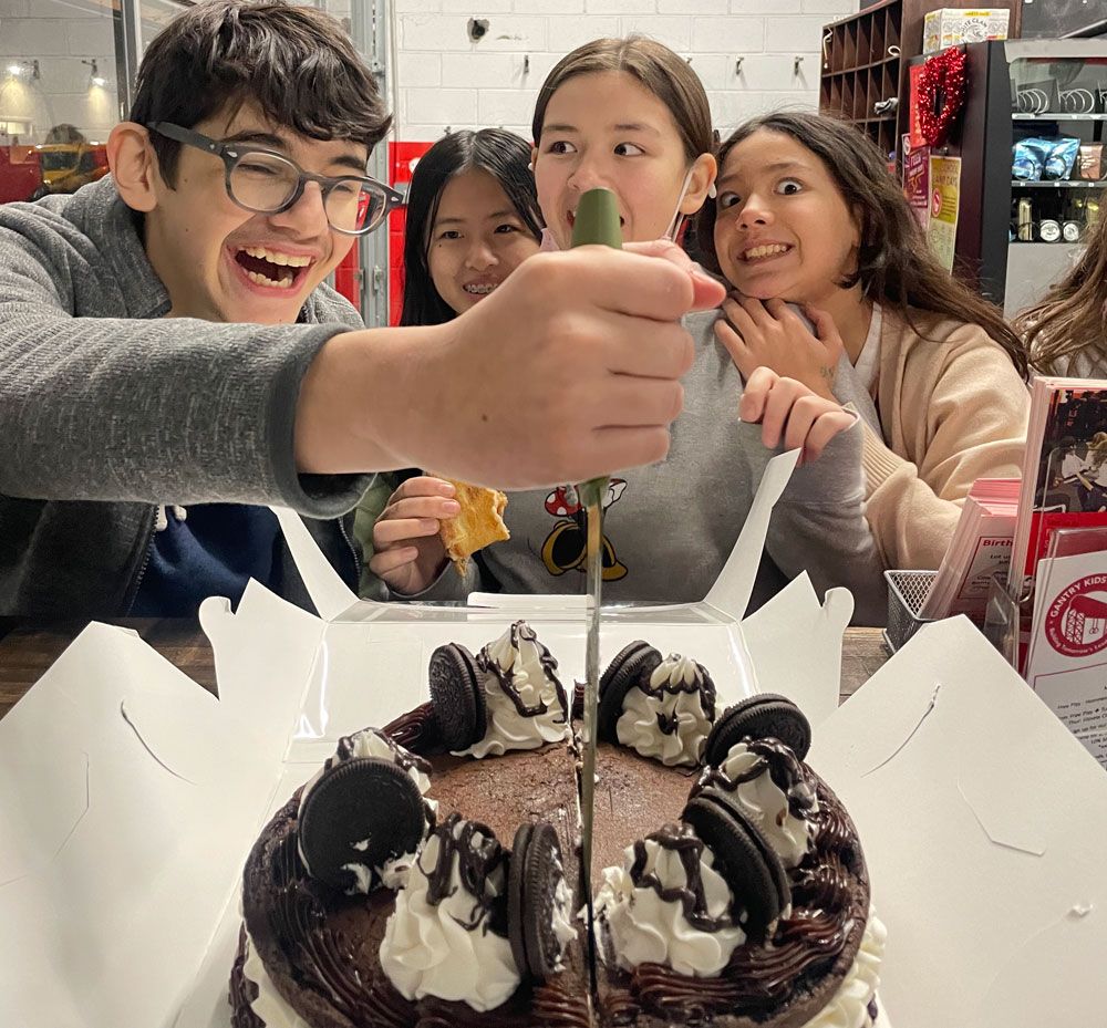 Kids cutting a cake together