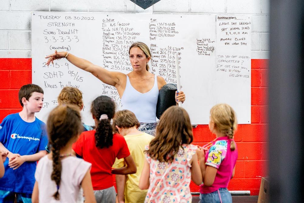 A coach at Gantry Kids in Long Island City talking to a group of children
