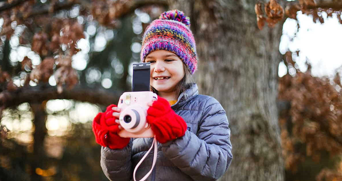 Kid taking picture in a fall setting