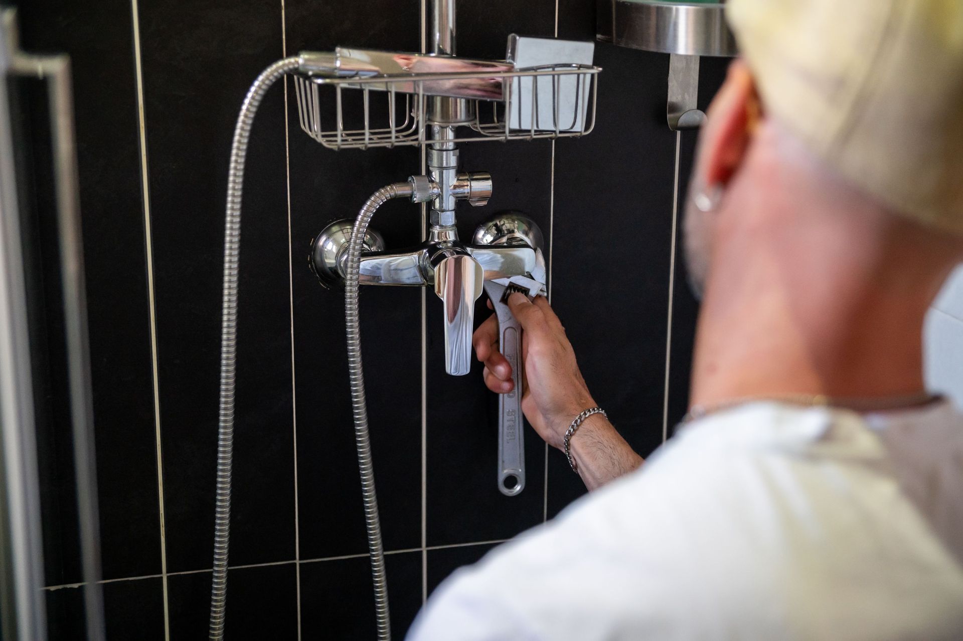 Un hombre está limpiando cortinas con una aspiradora.
