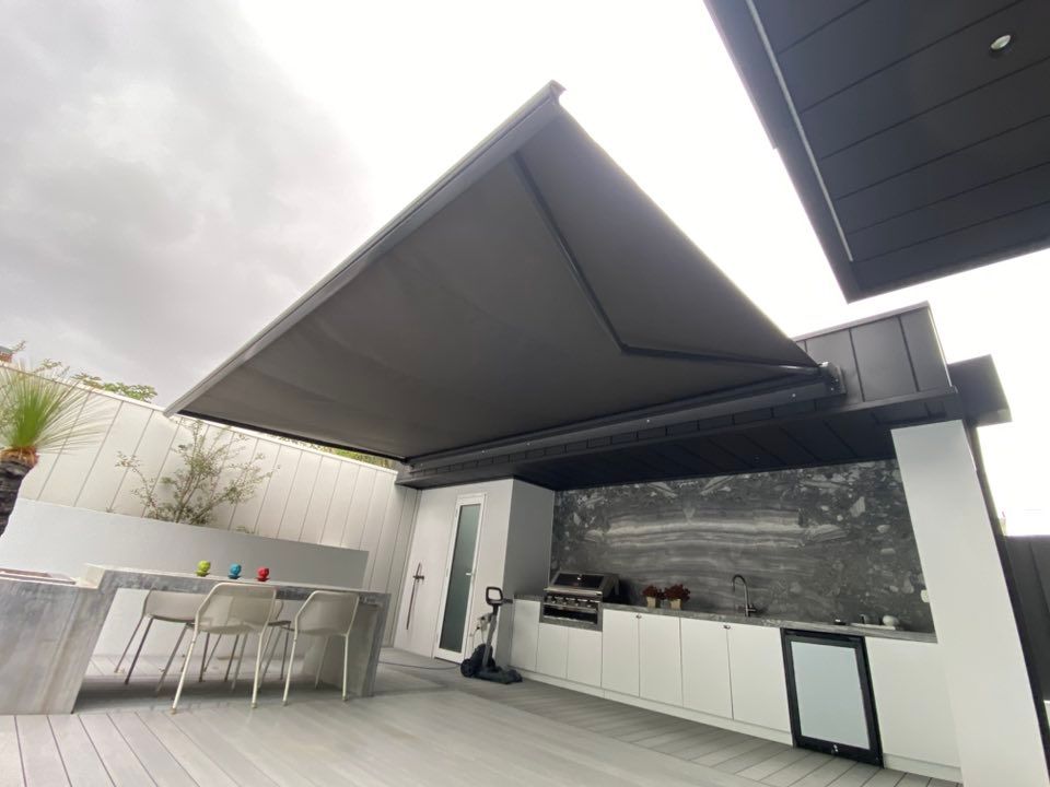 A Kitchen With A Table And Chairs Under An Awning  — Night & Day Blinds and Awnings in Pakenham, VIC