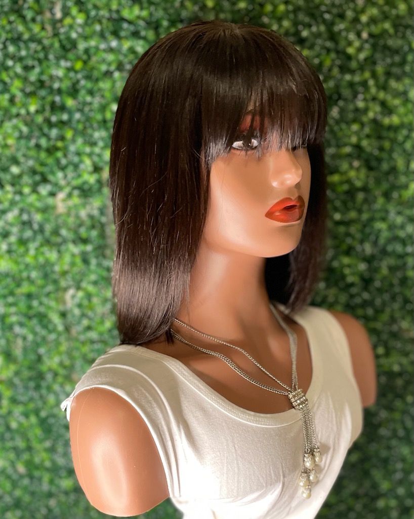 A mannequin is wearing a wig and a necklace.