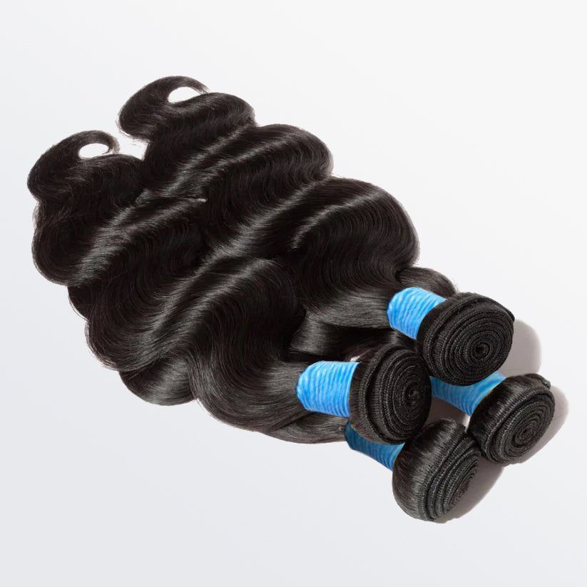 A bunch of hair extensions are stacked on top of each other on a white surface.