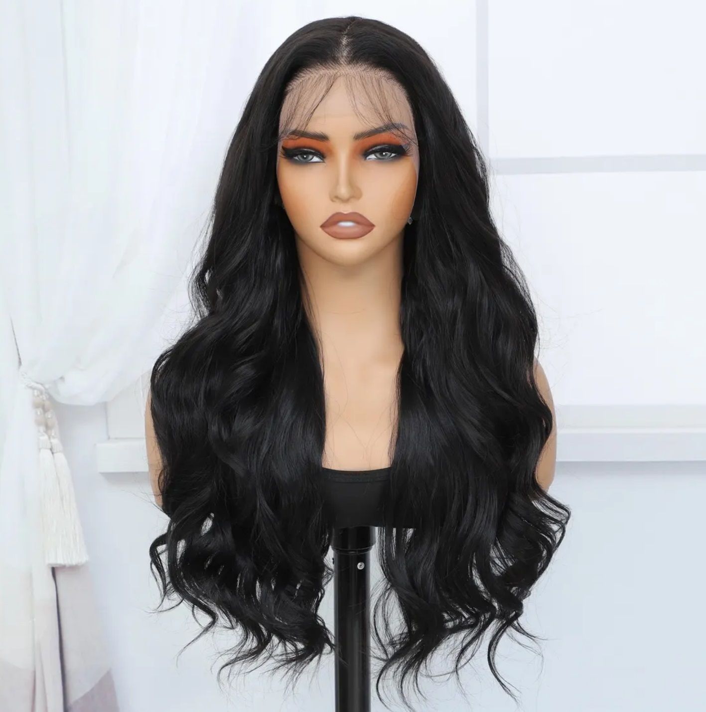 A black lace front wig is sitting on top of a mannequin head.