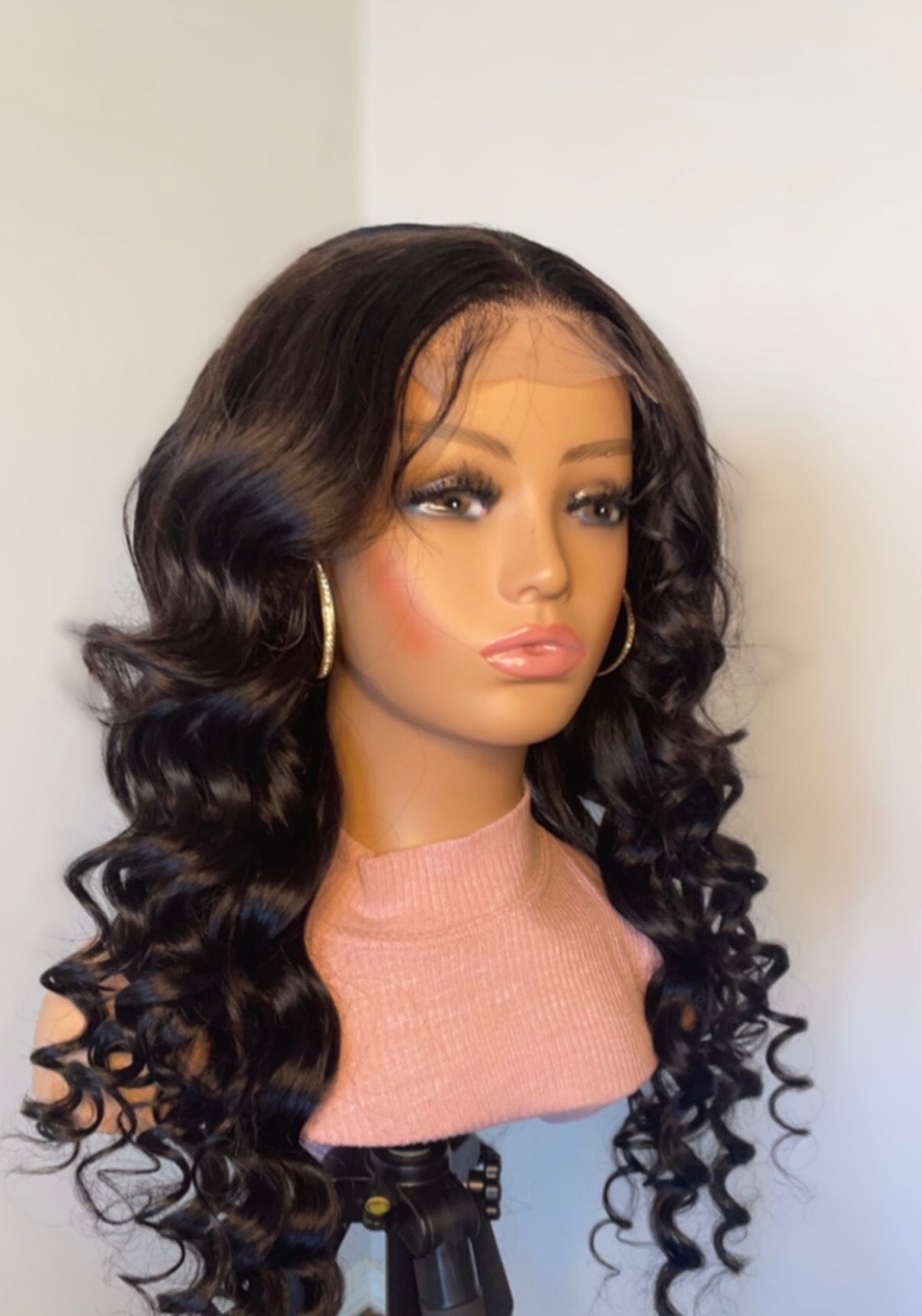 A mannequin is wearing a wig and earrings.