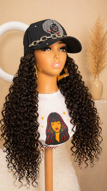 Woman in a black cap and white graphic tee posing by a park bridge with a city skyline behind her