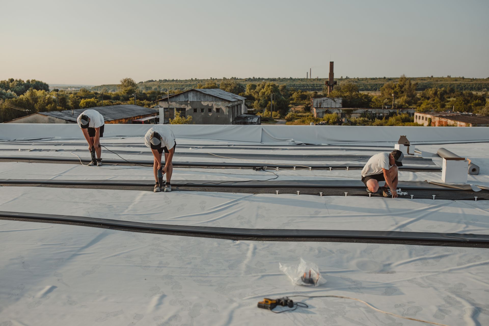 Commercial roofing contractors installing synthetic membrane for a new commercial roof.