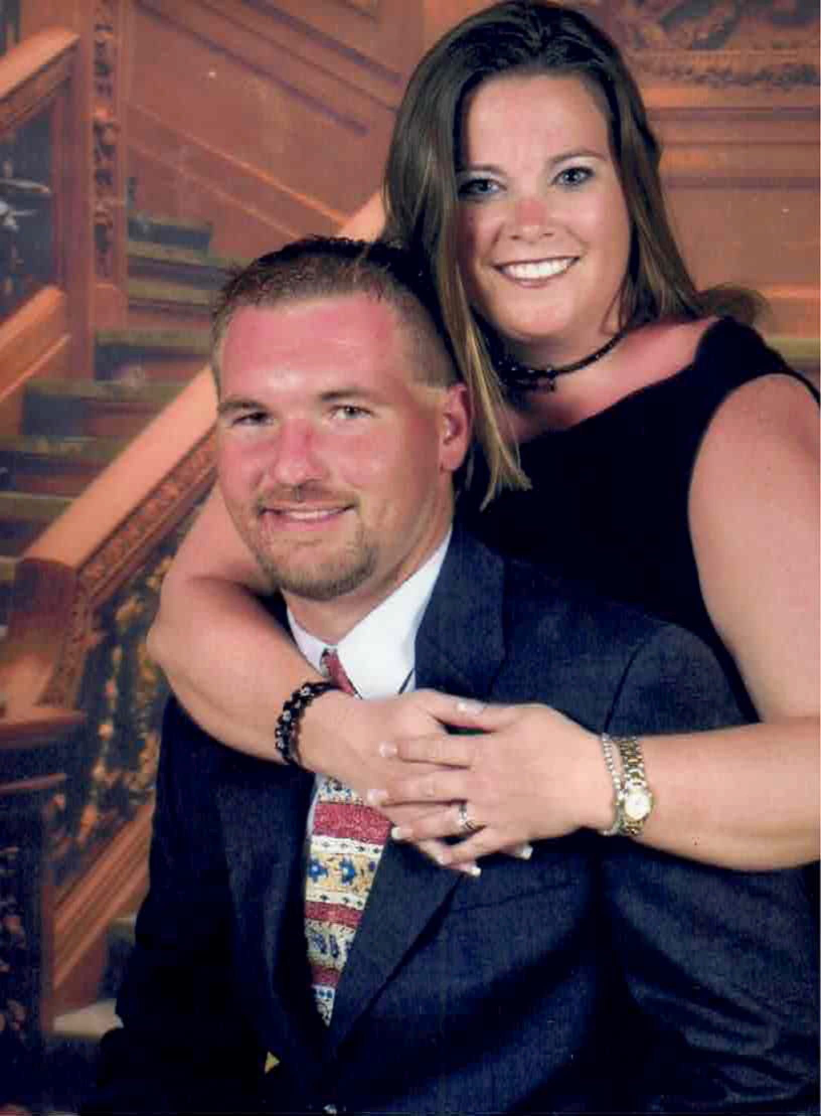 A man and woman posing for a picture with stairs in the background