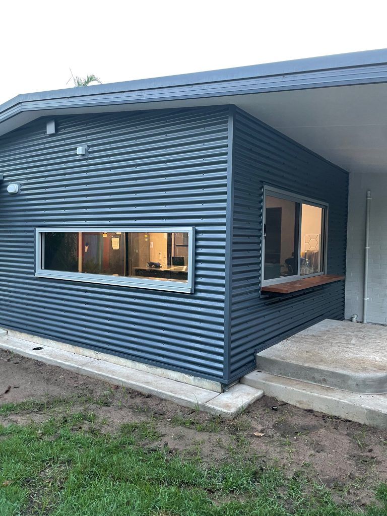 A Small House With a Large Window on the Side of It — Ideal Glass In Winnellie, NT