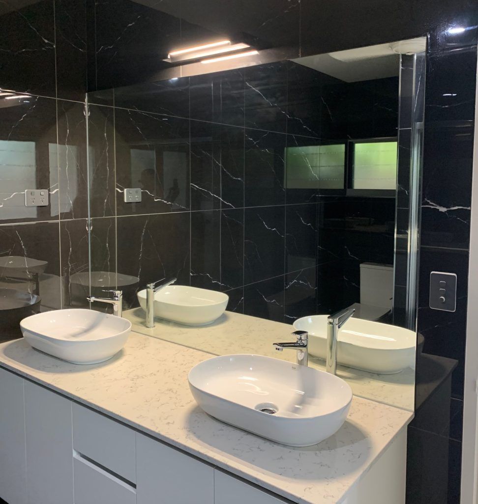 A Bathroom With Two Sinks and a Large Mirror — Ideal Glass In Winnellie, NT
