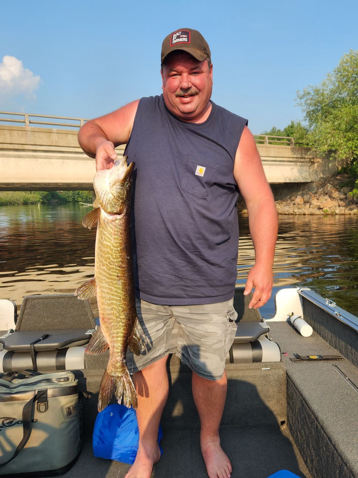 A man is standing on a boat holding a large fish