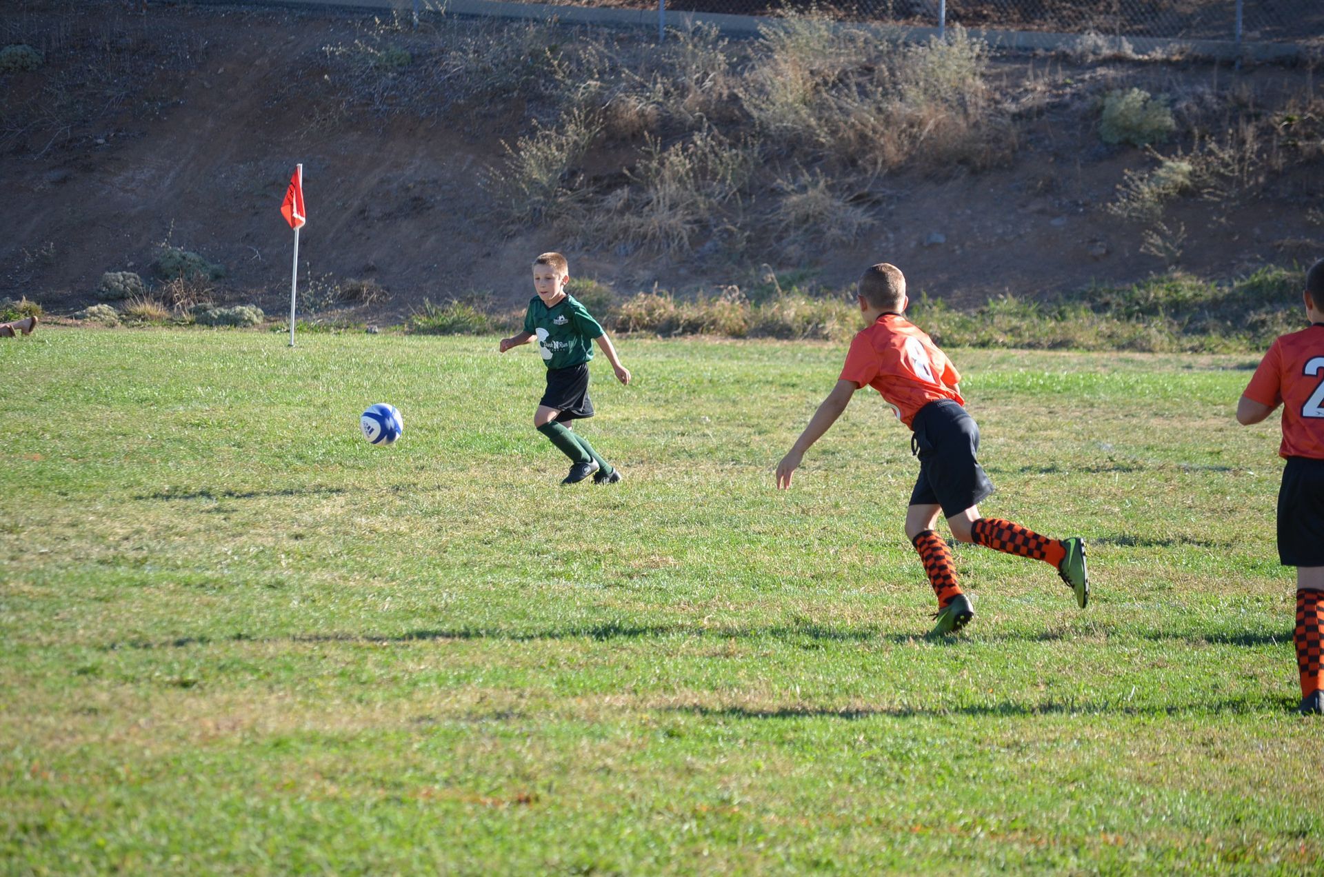 Baseball player sliding into base as another player attempts to catch the ball.