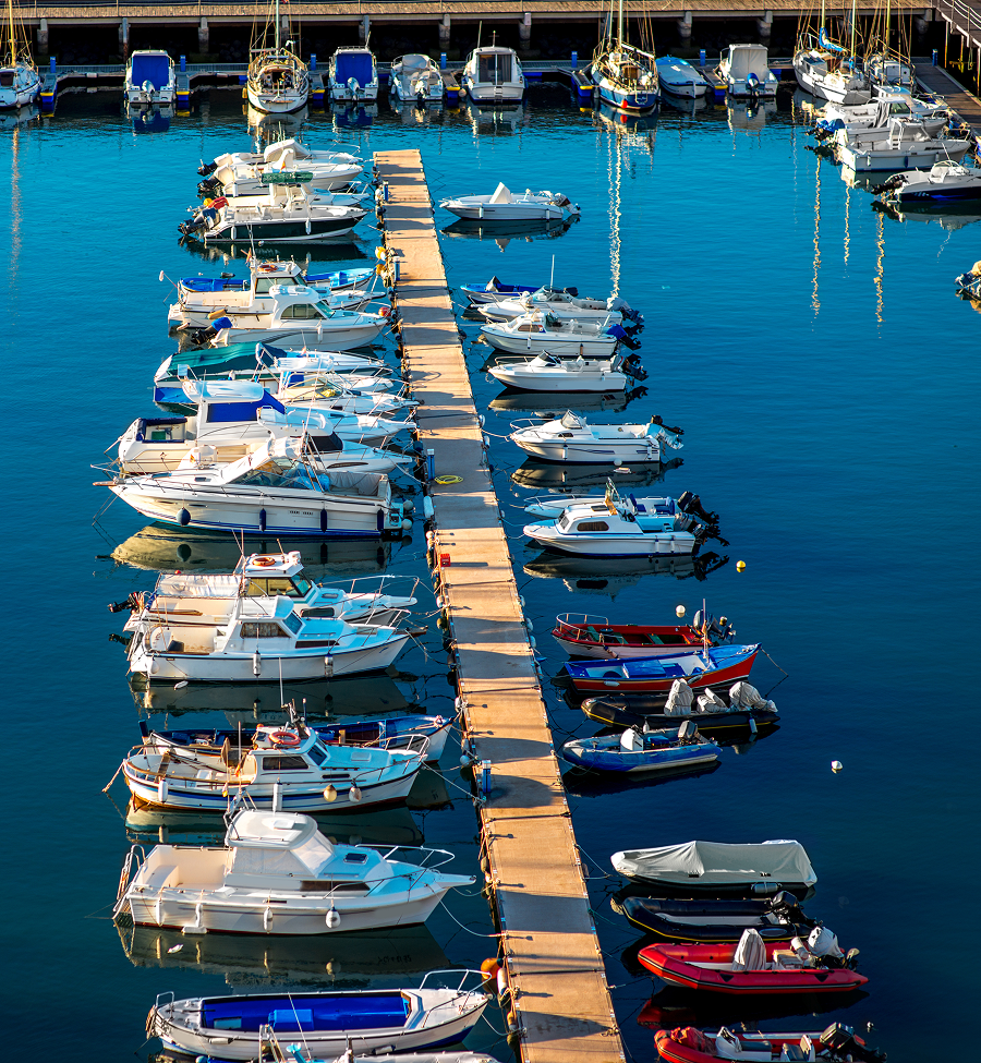 Many boats are docked at a dock in the water