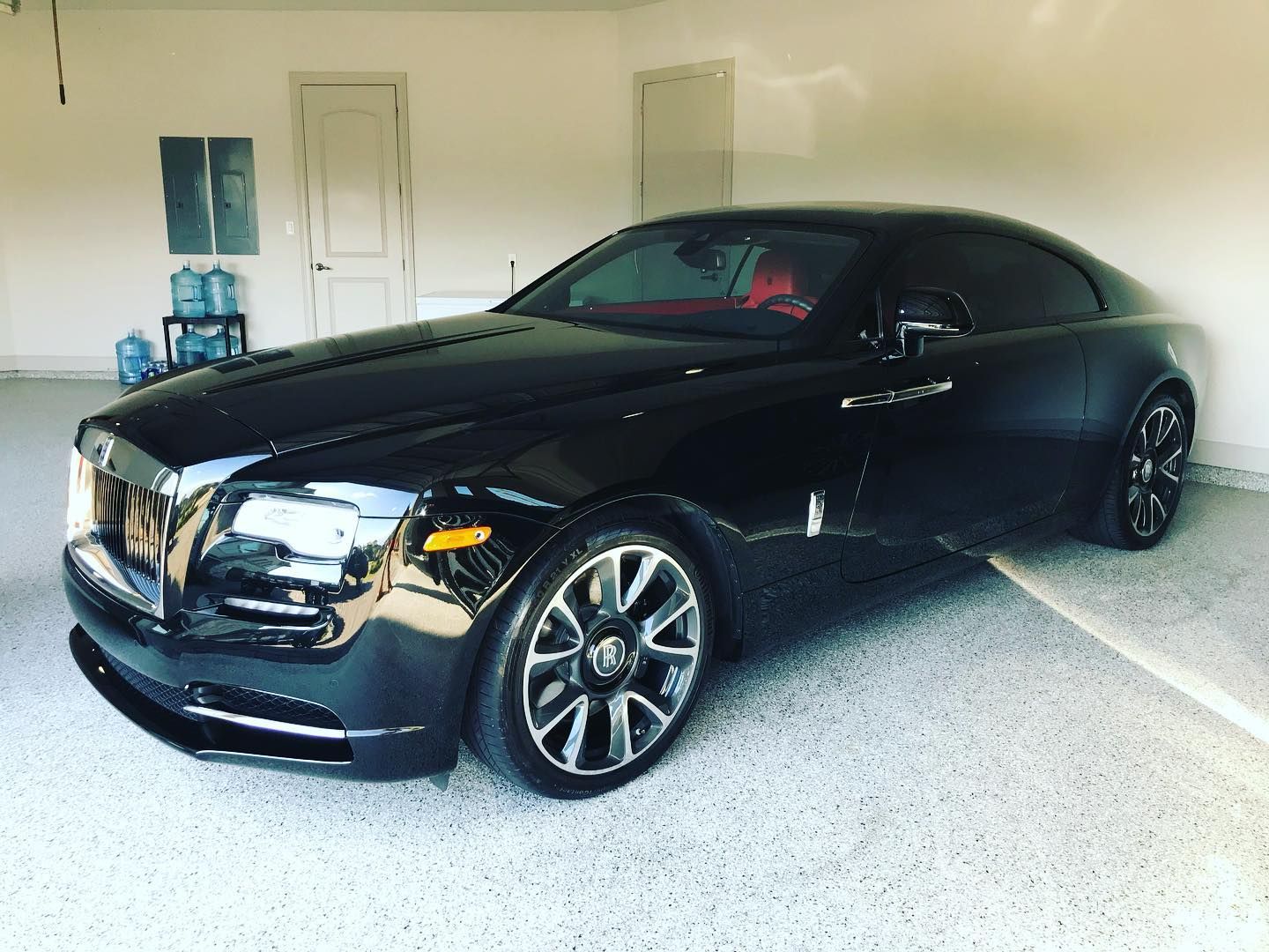 A black car is parked in a garage. A black car is parked in a garage.