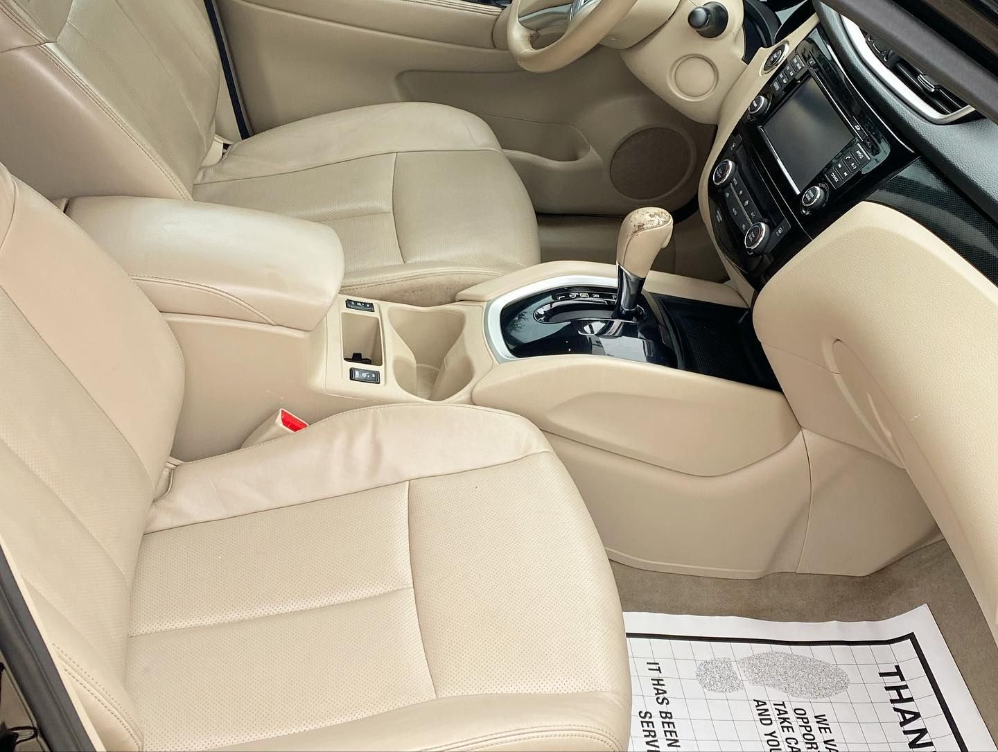 The inside of a car with a thank you paper on the floor The inside of a car with a thank you paper on the floor