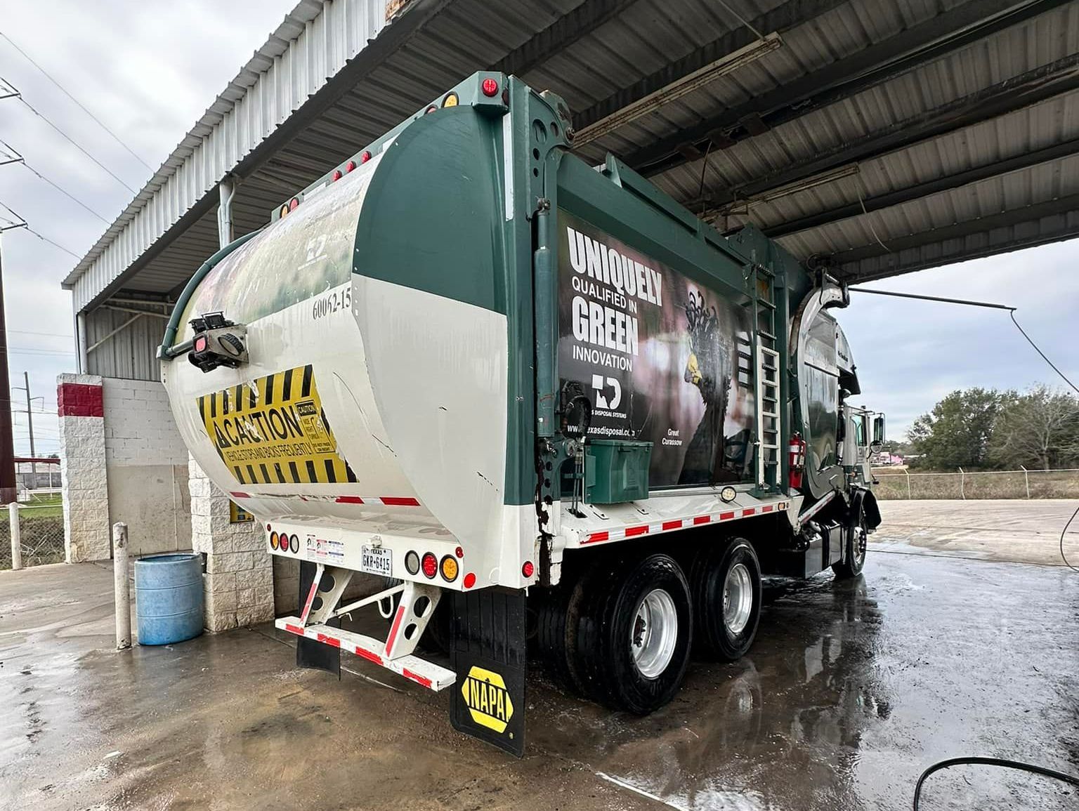 A garbage truck is being washed in a car wash. A garbage truck is being washed in a car wash.
