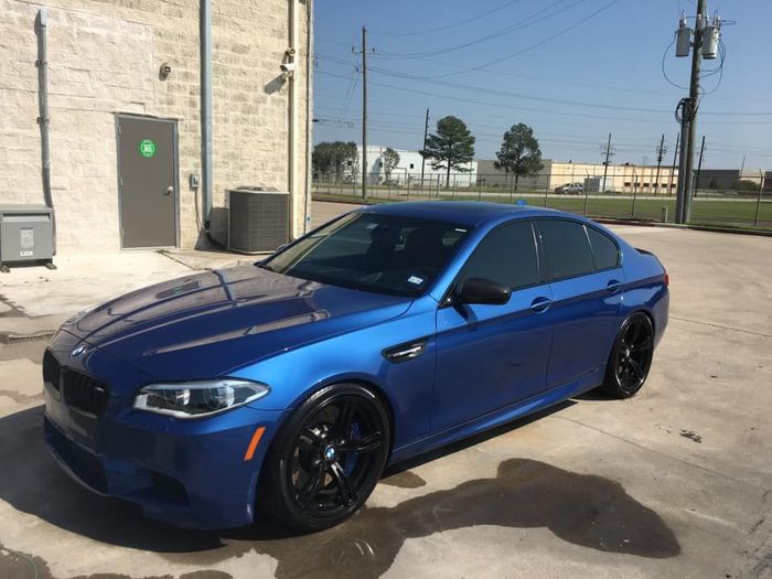 A blue bmw m5 is parked in front of a building. A blue bmw m5 is parked in front of a building.