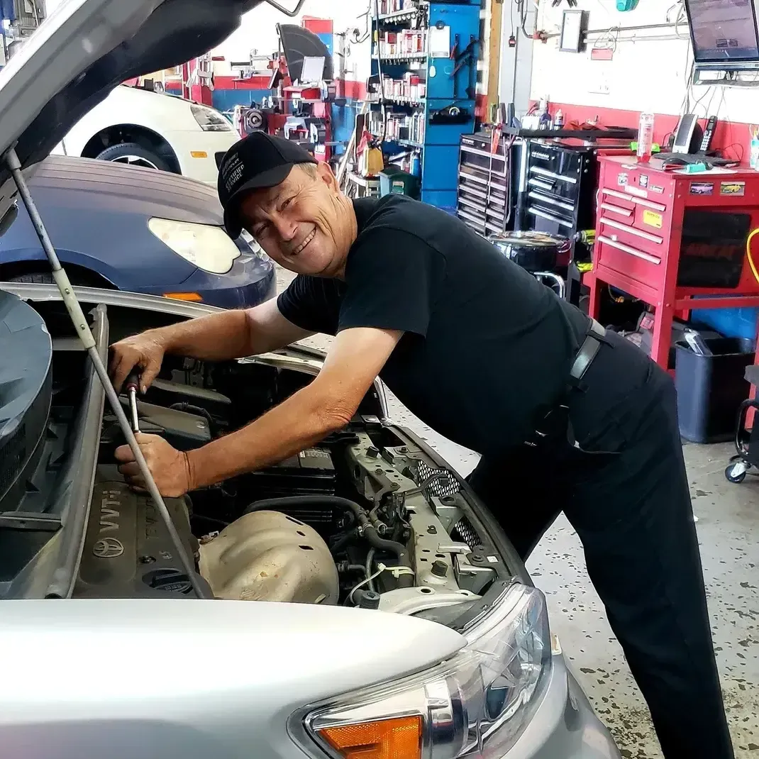 Mechanic working on silver car | Crossroads South Automotive