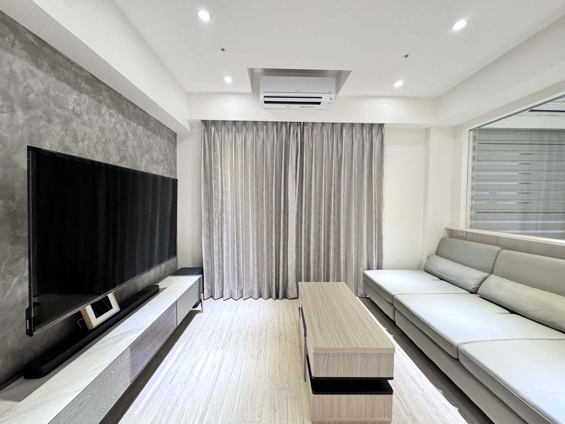 A living room with a couch and a flat screen tv.