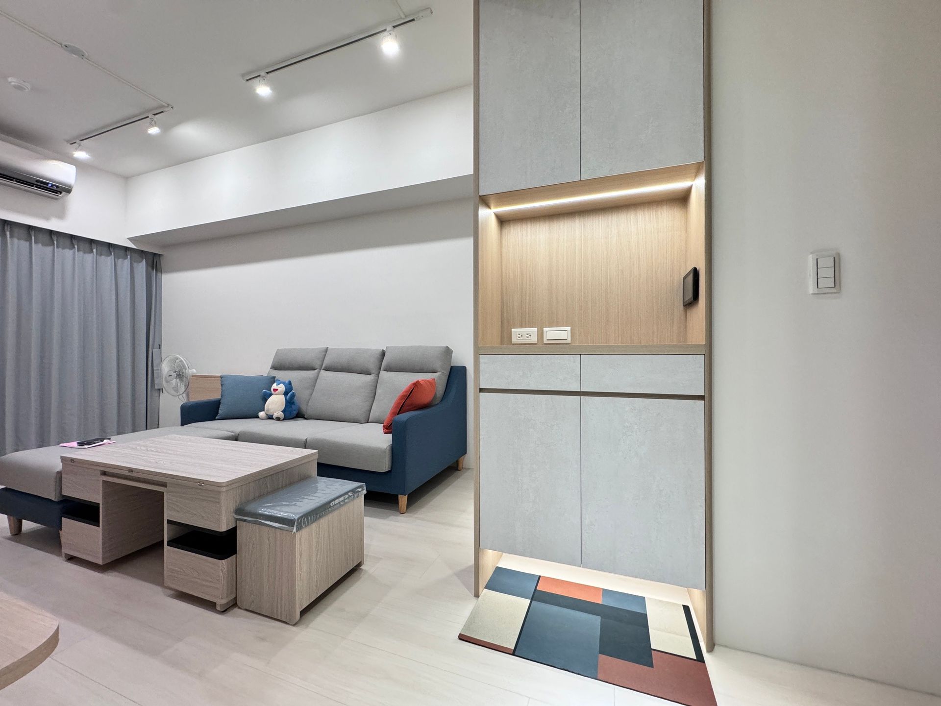 A living room with a couch , coffee table , and ottoman.