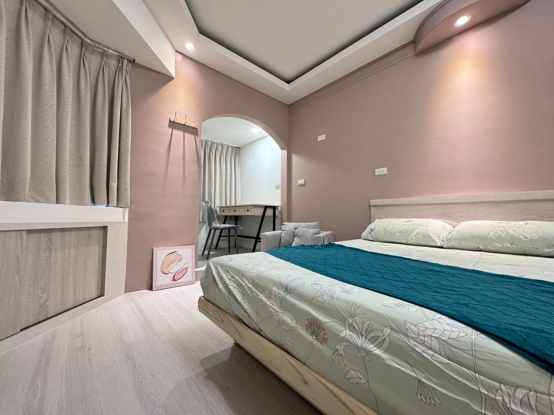 A bedroom with a bed and a desk in it.