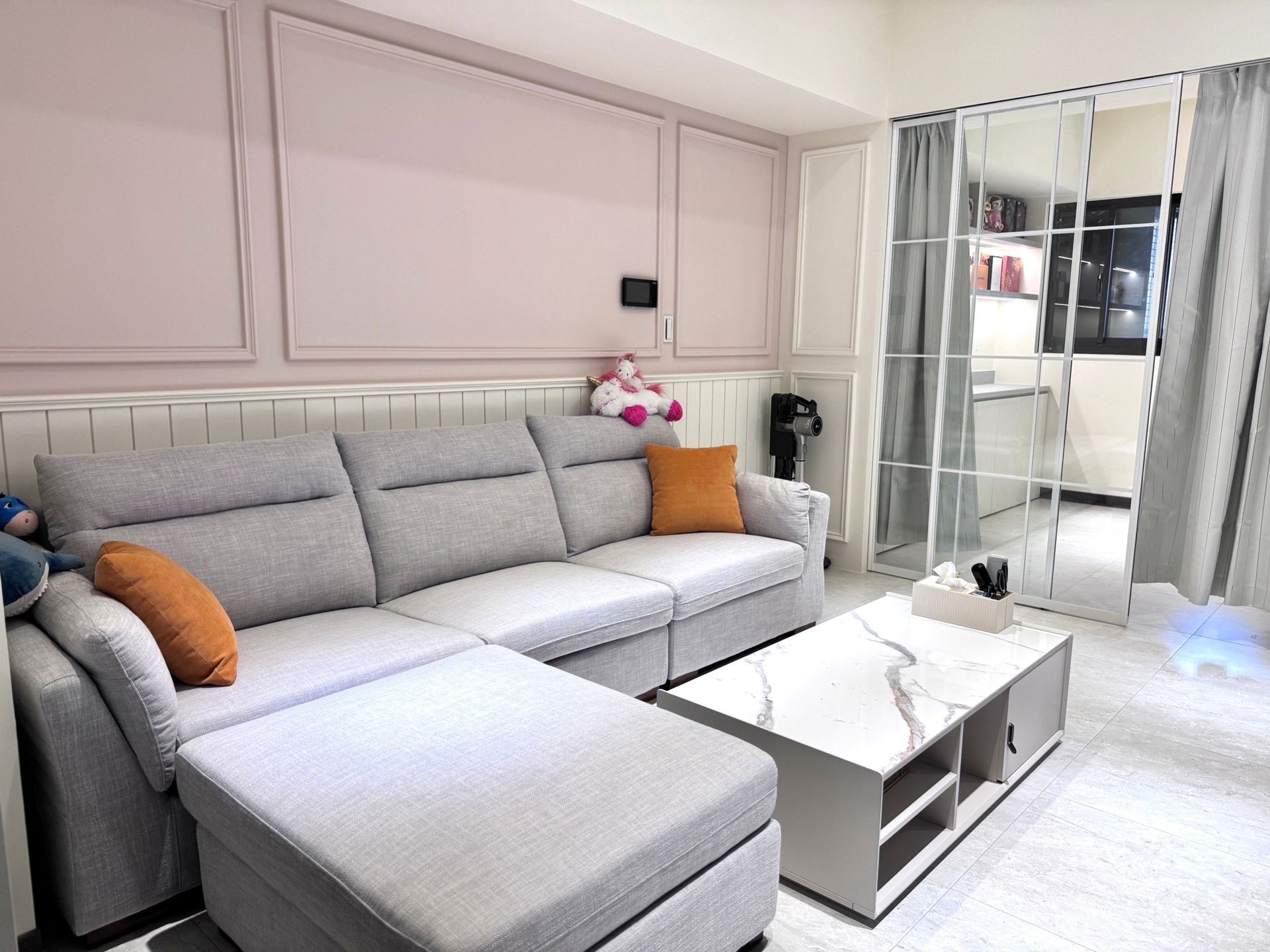 A living room with a couch , coffee table , and sliding glass doors.