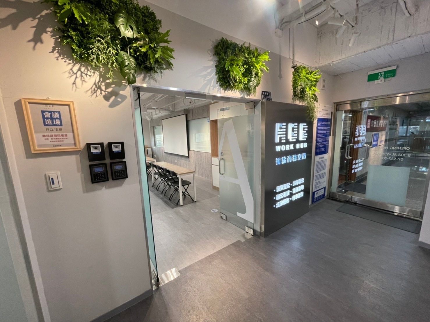 A hallway with a glass door leading to a room with a table and chairs.