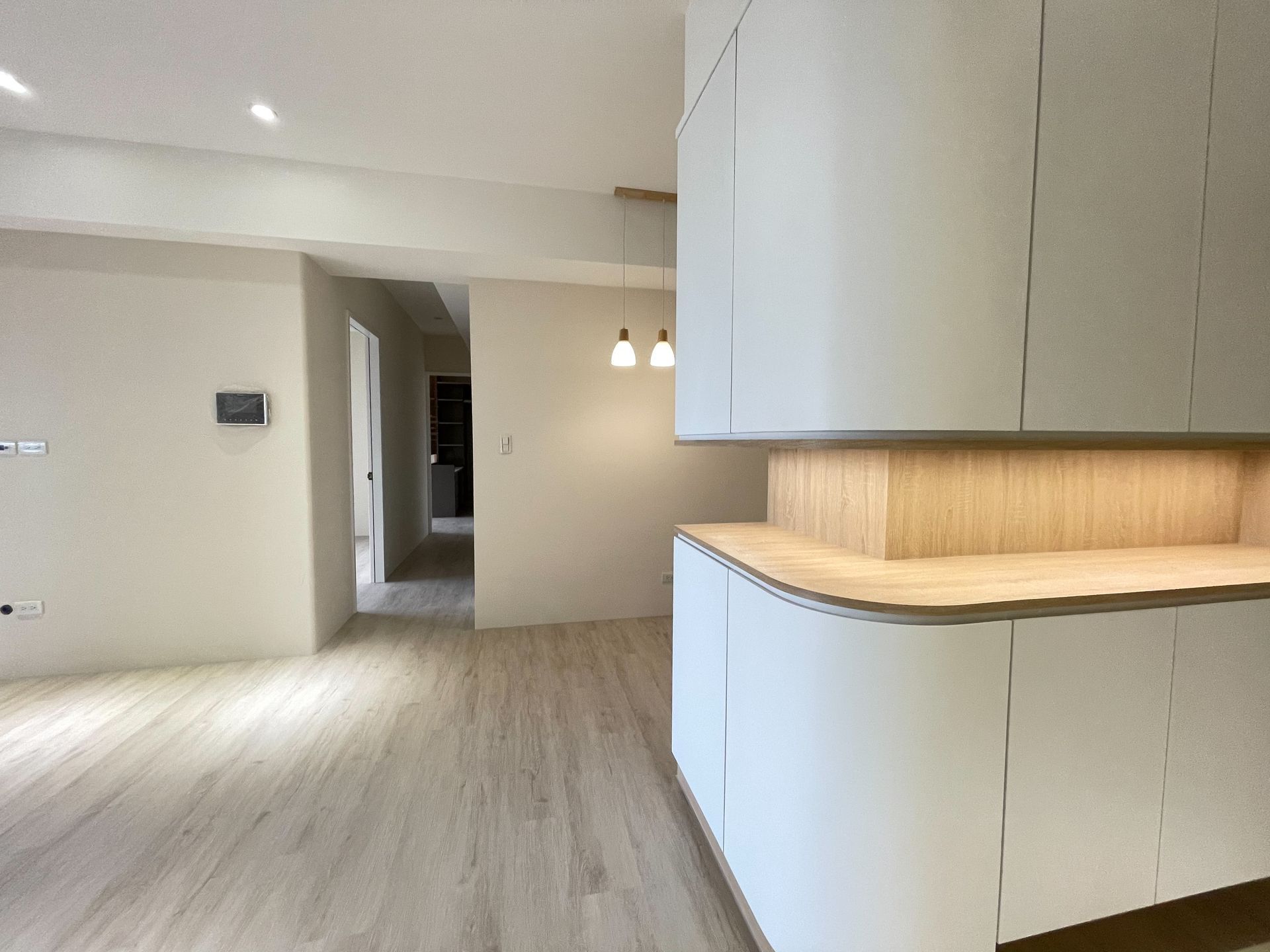 A kitchen with white cabinets and a wooden counter top.