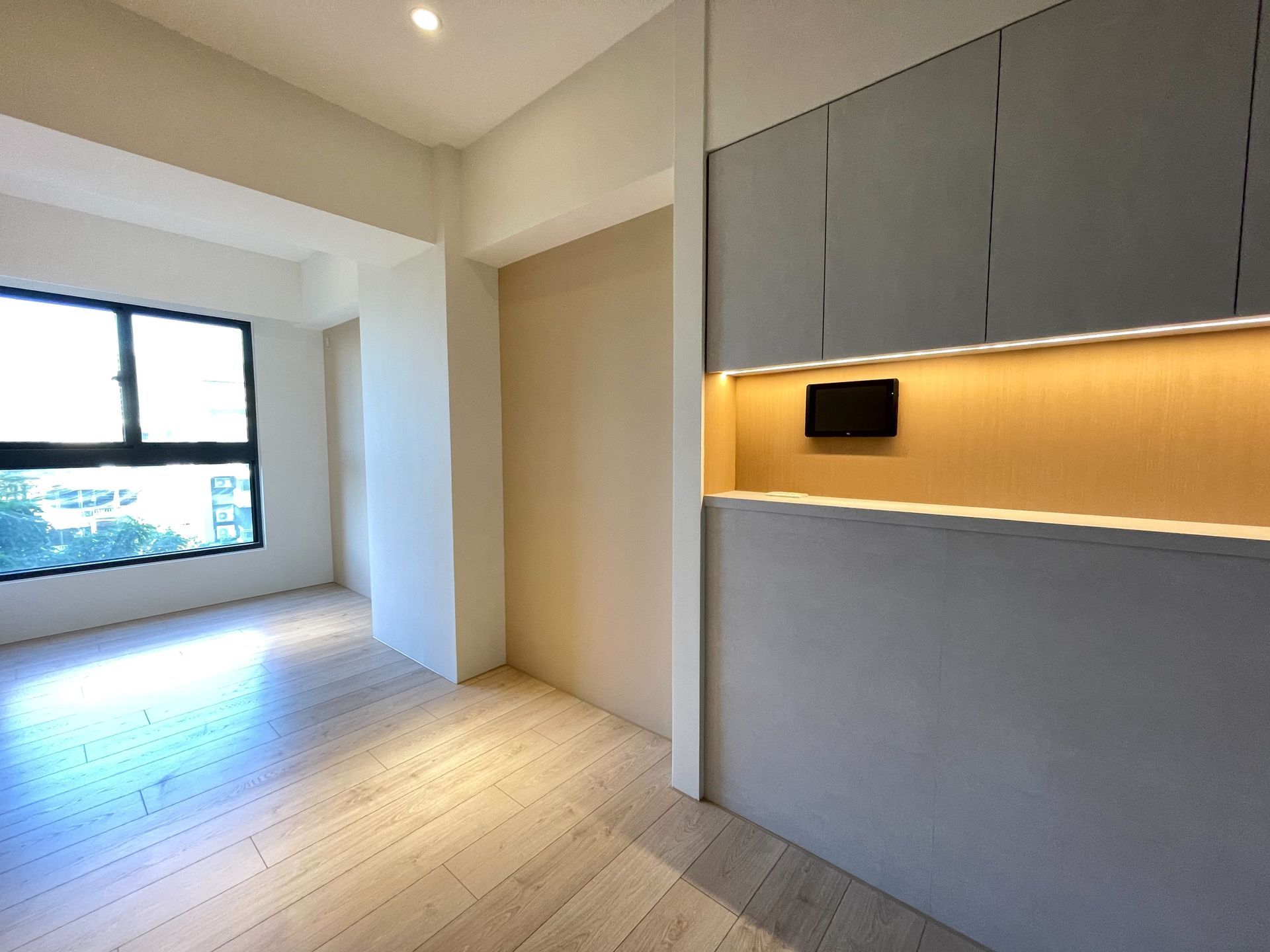 A living room with hardwood floors and a large window.