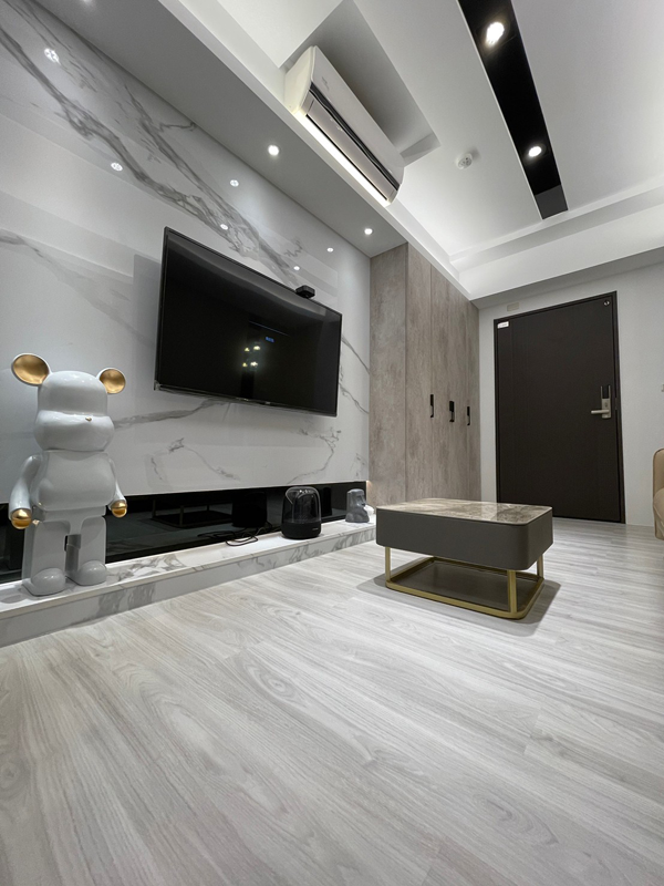 A living room with a large flat screen tv on the wall.