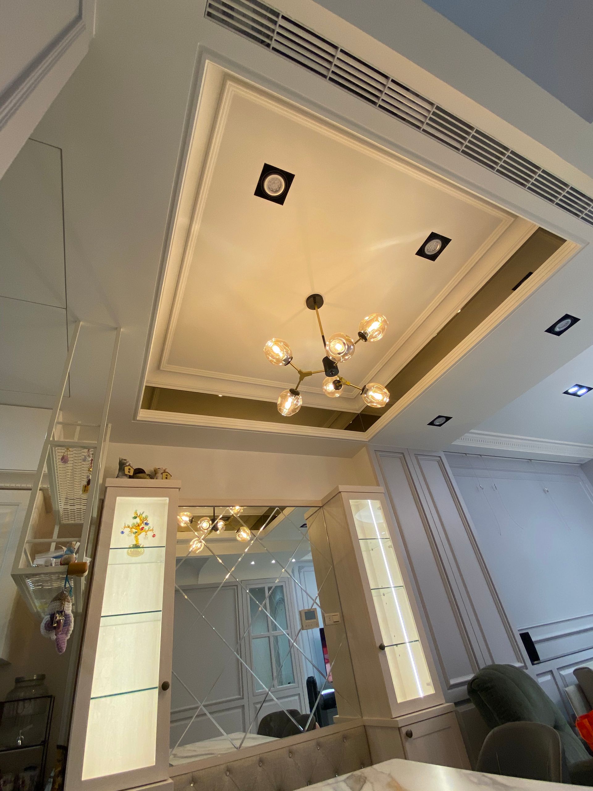 A living room with a chandelier hanging from the ceiling.