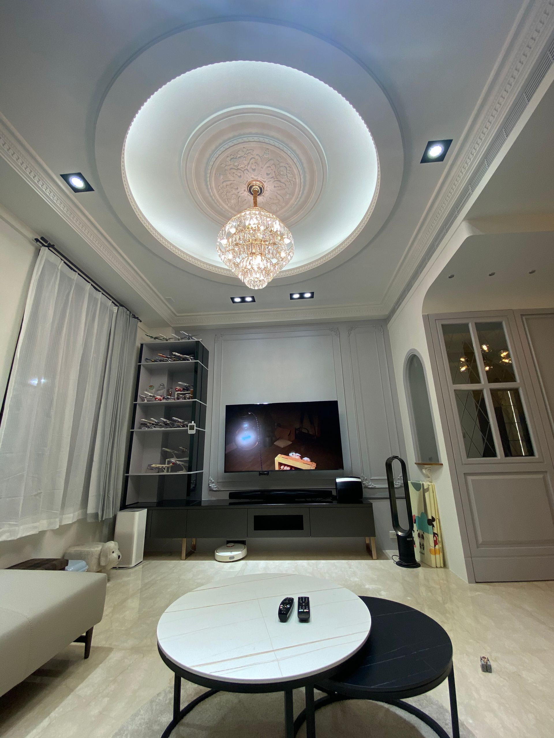 A living room with two coffee tables and a flat screen tv.