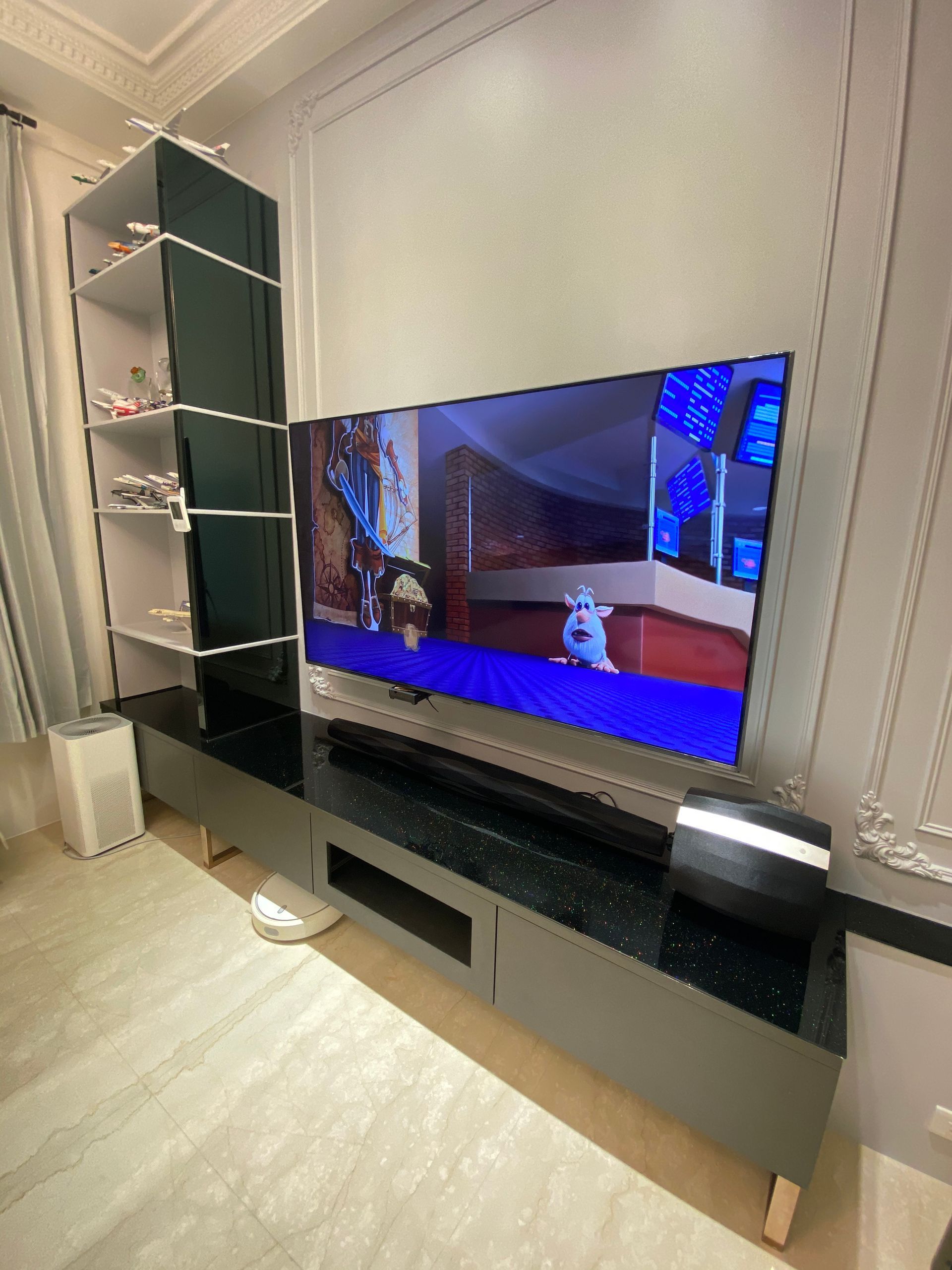 A large flat screen tv is sitting on top of a black entertainment center in a living room.