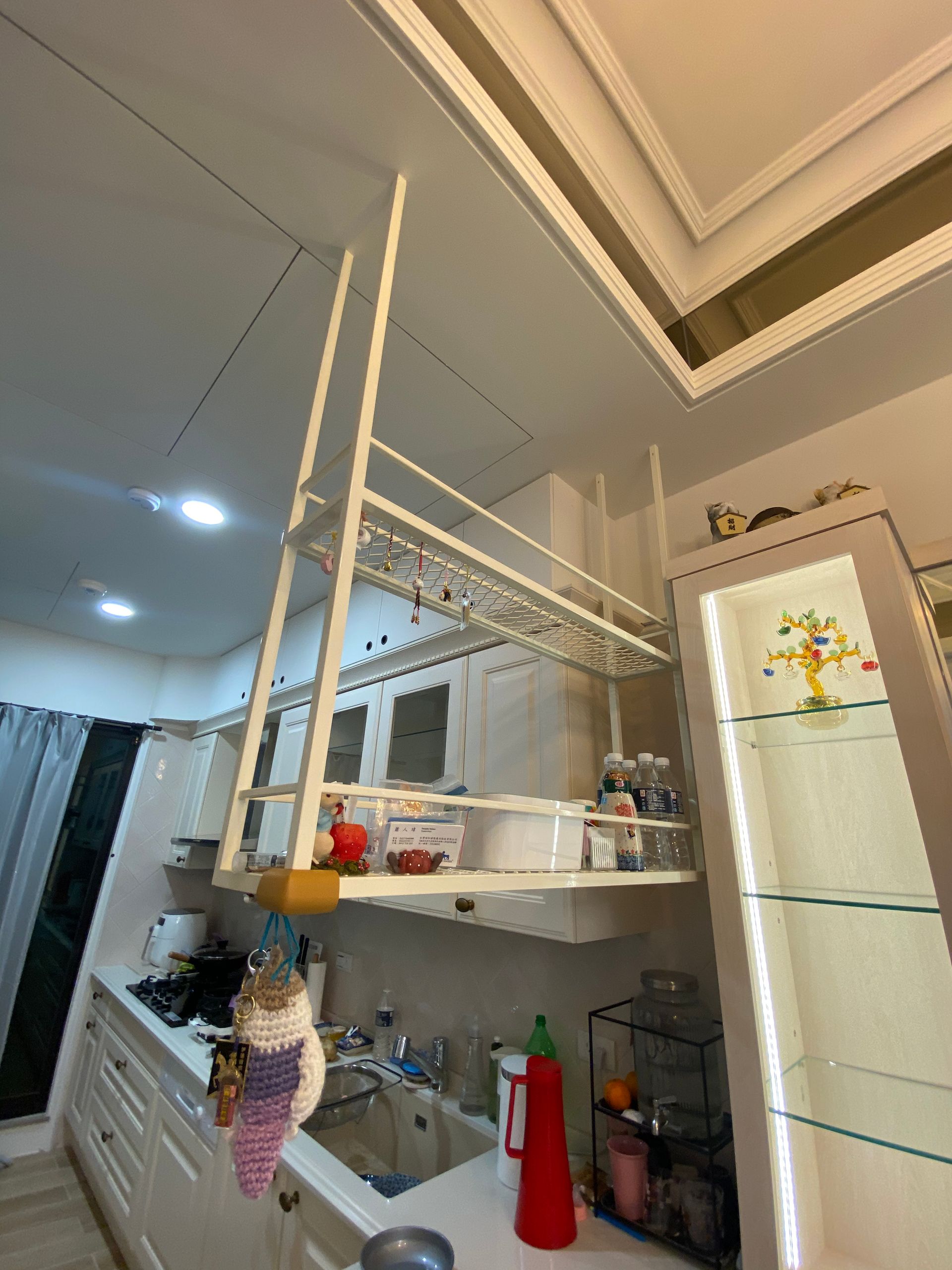 A kitchen with a ladder hanging from the ceiling.