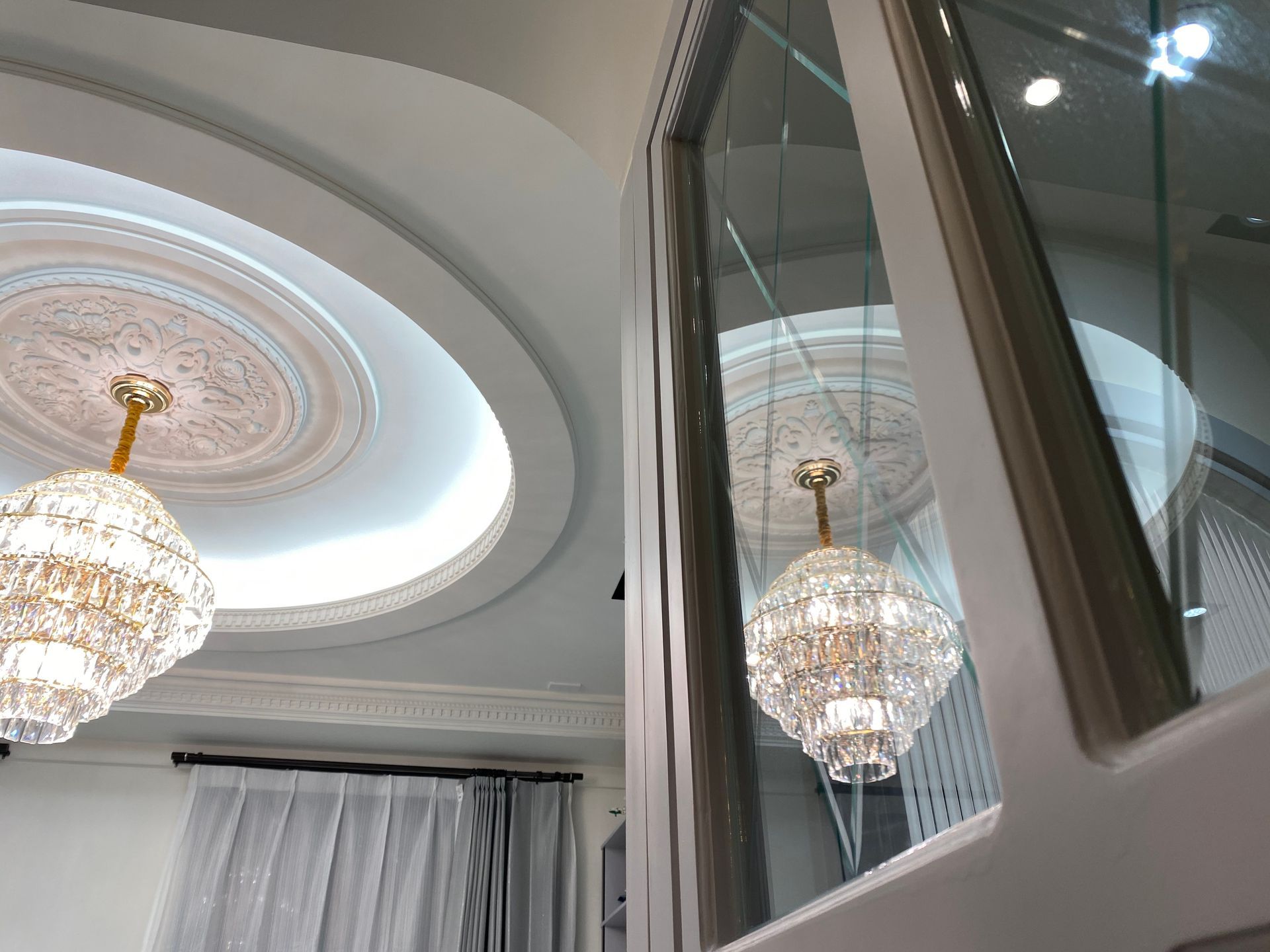 Two chandeliers are hanging from the ceiling of a room