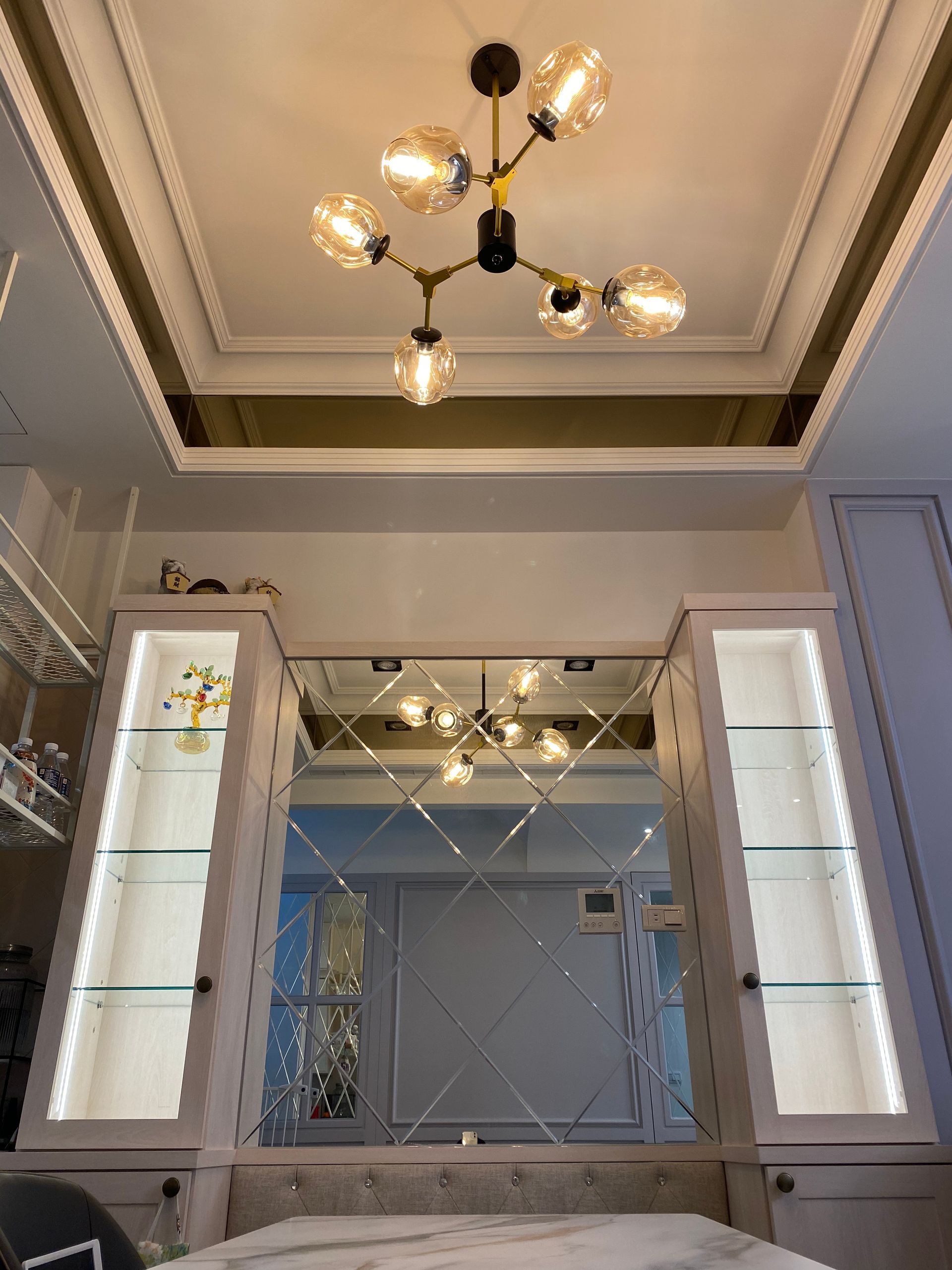 A bedroom with a mirror and a chandelier hanging from the ceiling.