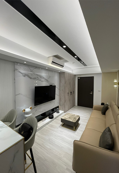 A living room with a couch , table , chairs and a flat screen tv.